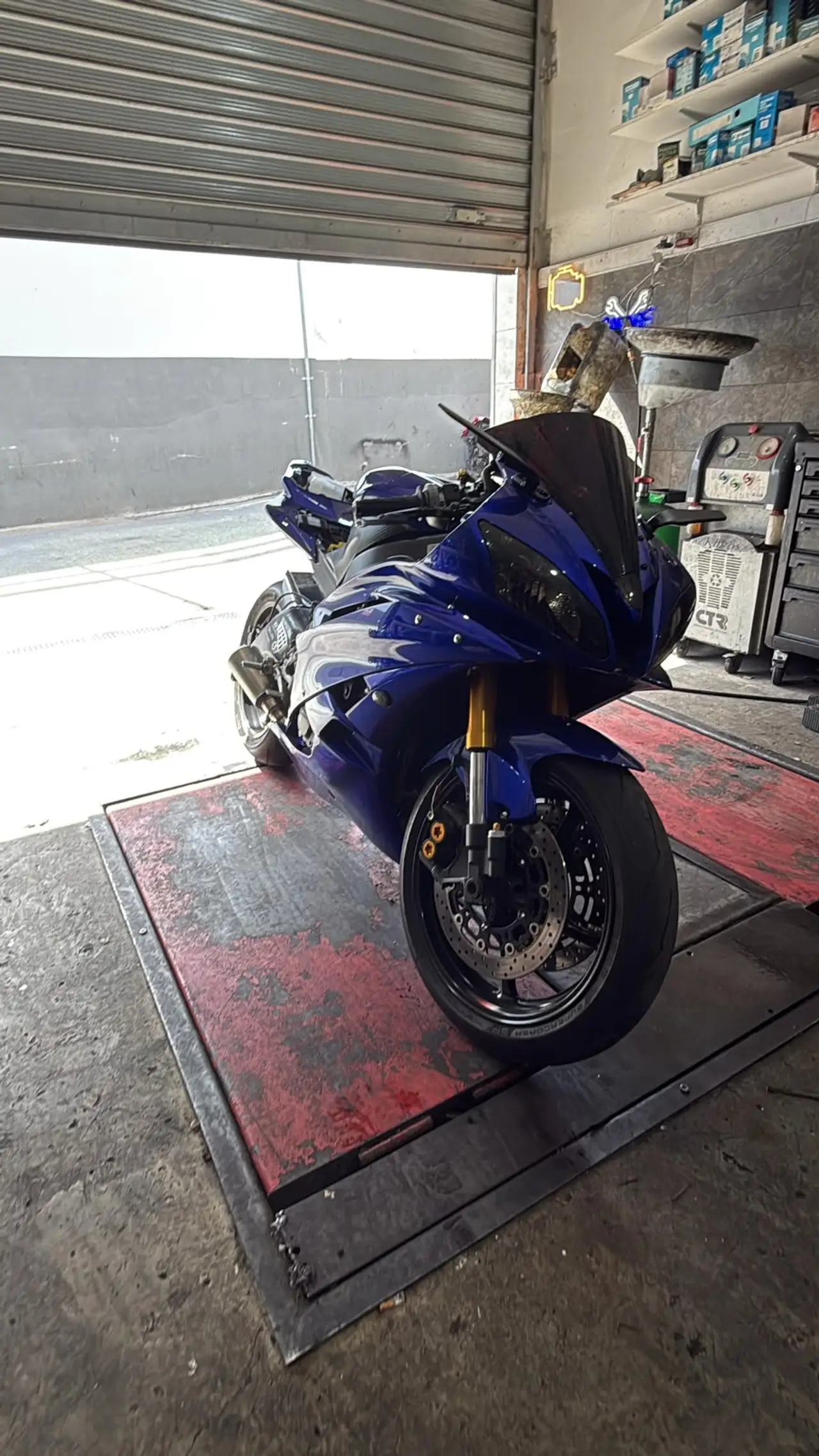Blue sport motorcycle positioned inside the workshop